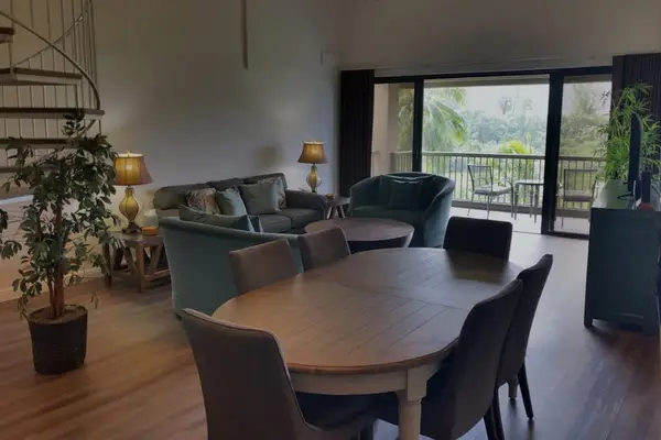 Dining area features round table, comfortable chairs, and balcony access