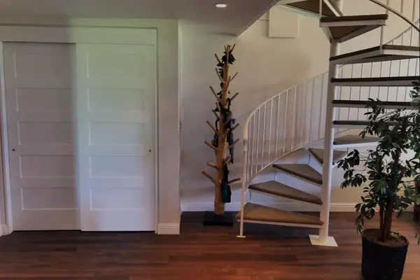 Entryway showcases staircase, decorative plants, convenient interior access, and nearby
