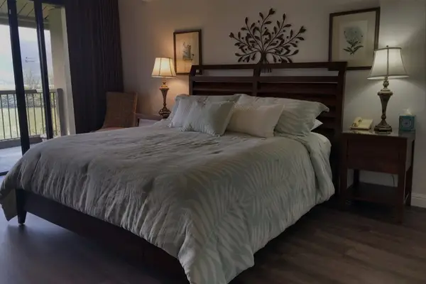 Primary bedroom showcases queen bed, bedside tables, and warm lighting