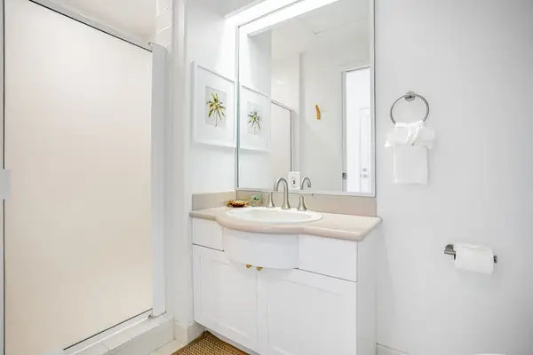 Bright and clean bathroom featuring a white vanity, updated fixtures, and ample mirror space