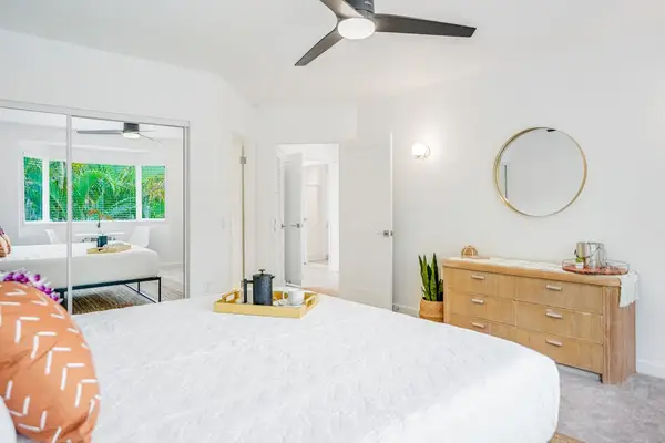 Serene main suite with plush king-size bed, decorative tray, and bright natural light
