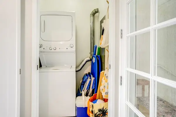 In-unit stacked washer and dryer with beach gear storage for guest convenience