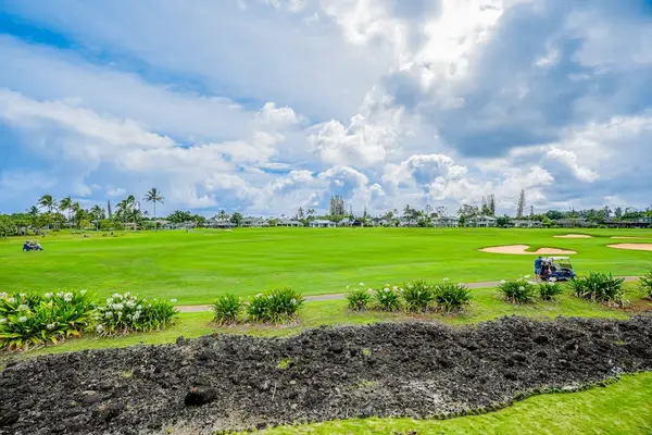 Expansive views of the lush golf course greens and fairways under vibrant island skies