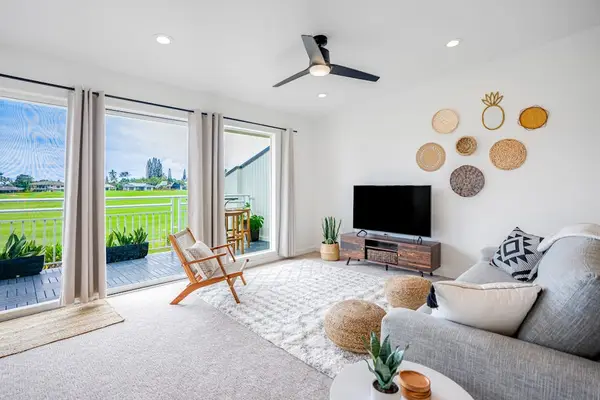 Sunlit living room with comfortable seating, smart TV, and sliding glass doors leading outdoors