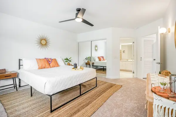 Bright and airy bedroom layout featuring natural light, ceiling fan, and stylish boho accents