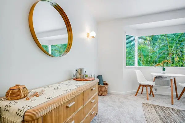 Stylish entryway vanity and mirror with natural light reflecting the serene interior decor