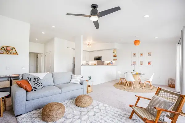 Comfortable living area with cozy sofa seating, ceiling fan, and bohemian accent decor