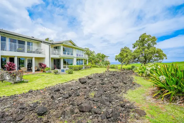Lush tropical landscaping and decorative lava rock accents at the complex entry