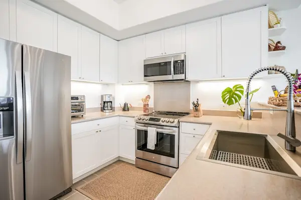 Fully equipped kitchen featuring clean white cabinetry, double sink, and high-end finishes