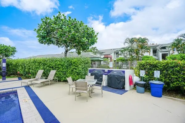 Resort-style pool area with lounge chairs and hot tub surrounded by tropical greenery