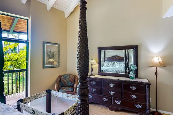 Elegant king bedroom featuring hand-carved wood details and garden views