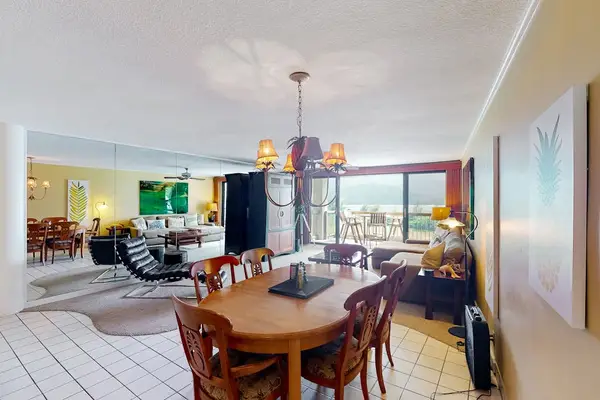 Open dining area connects with kitchen, seating, and tropical views
