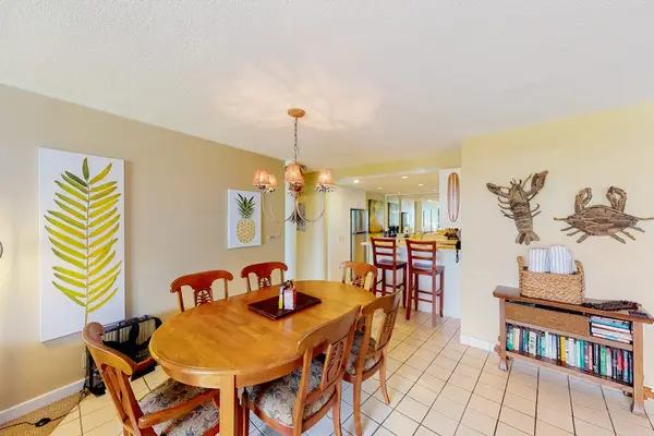 Dining room features round table, artwork, and open living access