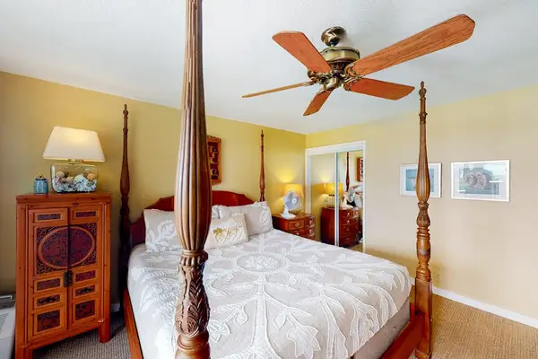 Elegant bedroom offers canopy bed, tropical artwork, and comfortable furnishings
