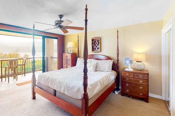 Primary bedroom features canopy bed, ceiling fan, and peaceful decor