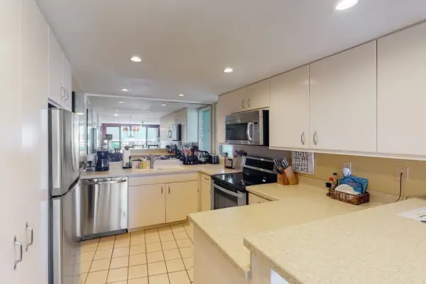 Bright kitchen features ample cabinetry, breakfast seating, and updated appliances
