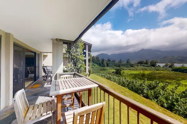 Covered balcony overlooks lush fields, mountain scenery, and tropical landscapes