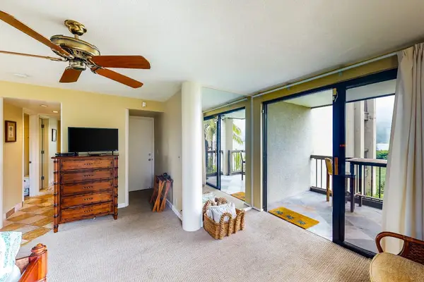 Studio opens toward balcony doors with natural light and seating