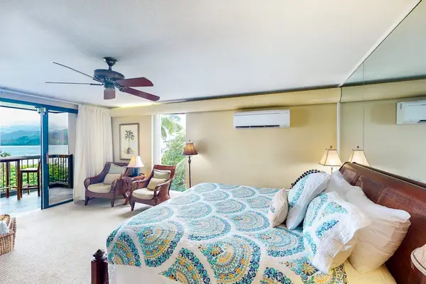 Spacious studio includes comfortable bedding, ceiling fan, and scenic balcony access