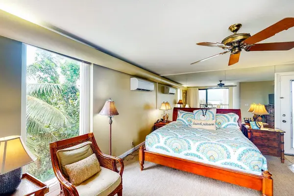 Bright studio offers seating, tropical views, and comfortable sleeping arrangements