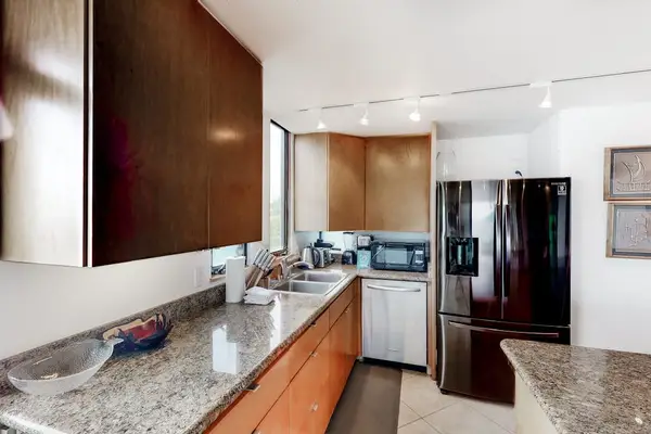 Modern kitchen features dark cabinetry, stainless appliances, and practical counters