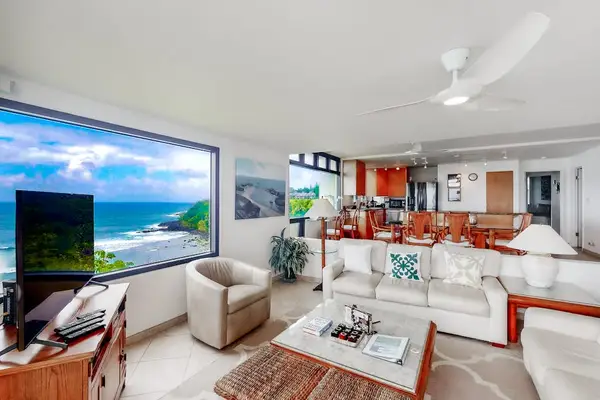 Open living area presents comfortable sofas, artwork, and water views