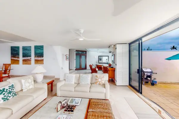 Bright living room showcases white furnishings, windows, and island decor