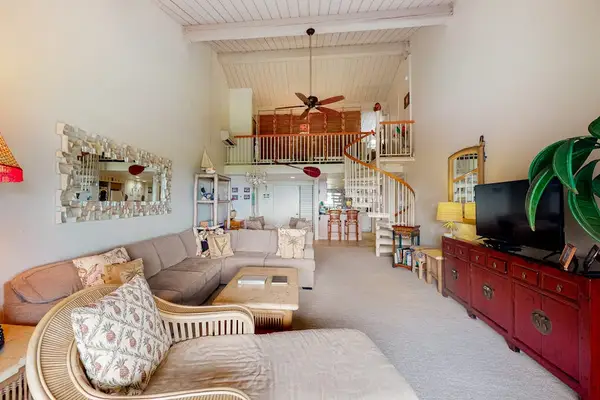 Sunlit living area showcases sofas artwork and tall windows today