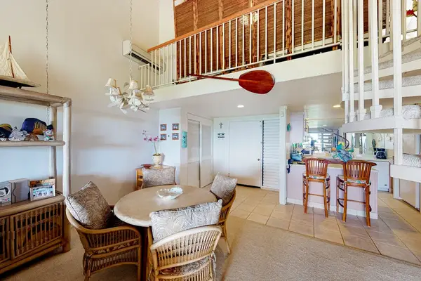 Living room features wicker seating dining table and mountain views