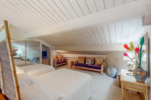 Bright bedroom corner includes neatly arranged bedding and coastal accents