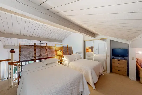 Cozy loft featuring two comfortable beds, perfect for restful stays