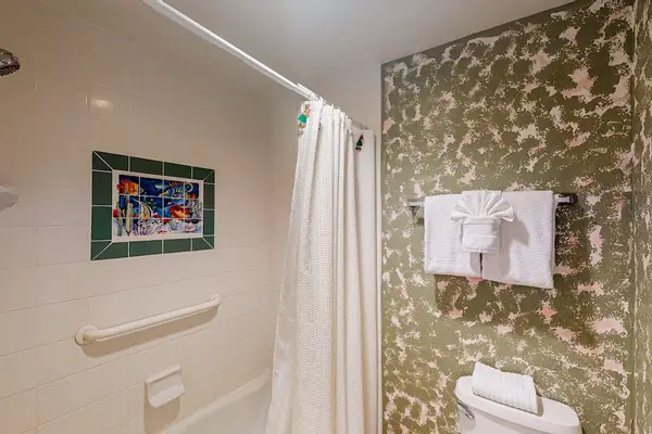 Patterned shower wall and fresh towels brighten this bathroom beautifully