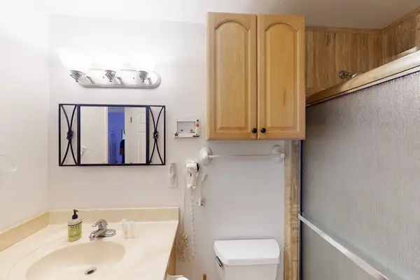Full bathroom features vanity sink mirror and ample storage cabinetry