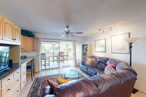 Glass walls brighten the living room while connecting effortlessly to the outdoor balcony