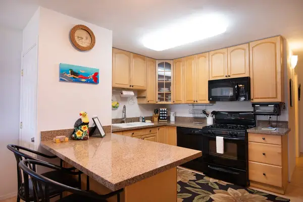Bright kitchen features wood cabinetry appliances and generous counter space