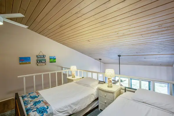 Three single beds located in the loft of the townhome.