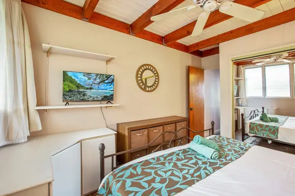 Master bedroom with king bed, flat screen tv and lots of windows.
