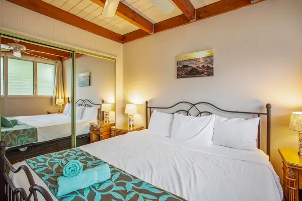Master bedroom with king bed, flat screen tv and lots of windows.