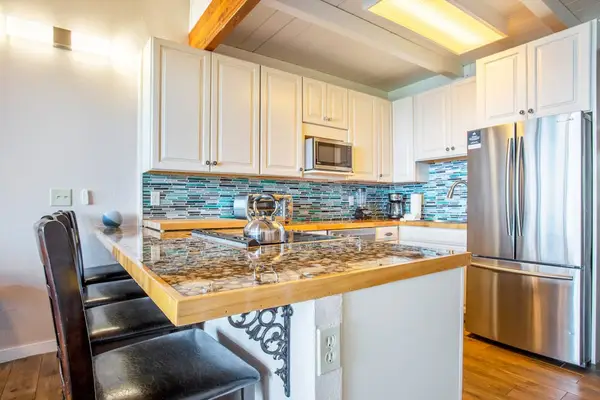 Kitchen counter with four barstools for extra seating.