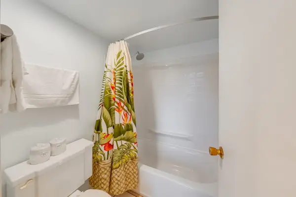 Bright bathroom features tiled walls a shower and convenient storage