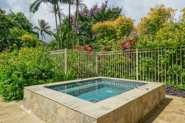 Unwind in the relaxing hot tub surrounded by lush tropical landscaping.