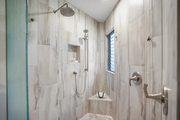 Walk-in shower with beautiful tilework and modern fixtures.