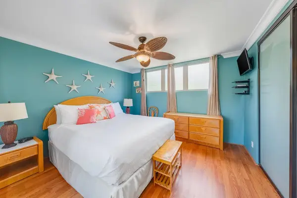 Airy bedroom includes a ceiling fan for enhanced comfort during warm tropical evenings