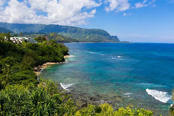 Panoramic coastline showcases turquoise waters, lush cliffs, and island scenery