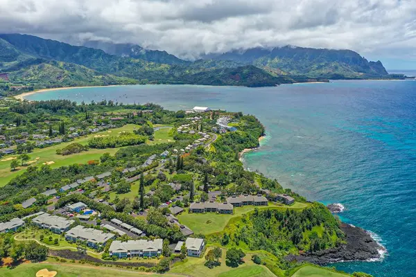 Expansive aerial scenery reveals green valleys, coastline, and scattered homes