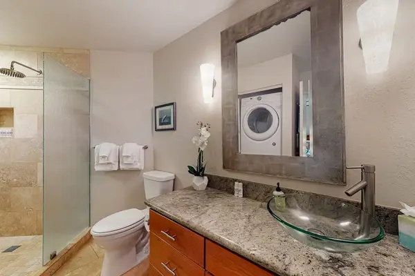 Well-organized bathroom offers a comfortable shower, mirror, and attractive details