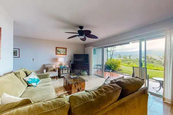 Coastal living room features comfortable seating and tropical views.