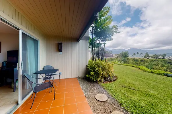 Covered patio features bistro seating, lush landscaping, and mountain views