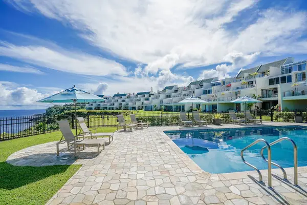 Sunlit pool area provides refreshing water beside scenic mountain surroundings