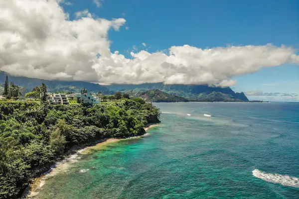 Aerial coastline view showcases turquoise waters, greenery, and island homes
